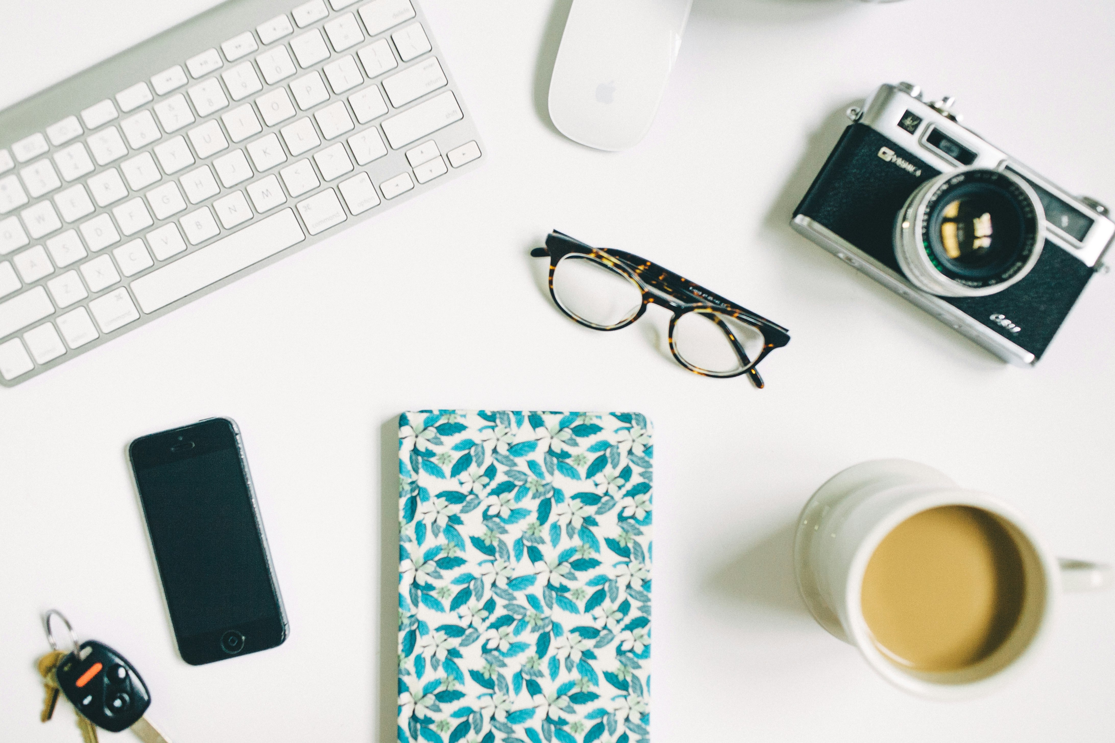 black frame eyeglasses beside black and gray SLR camera